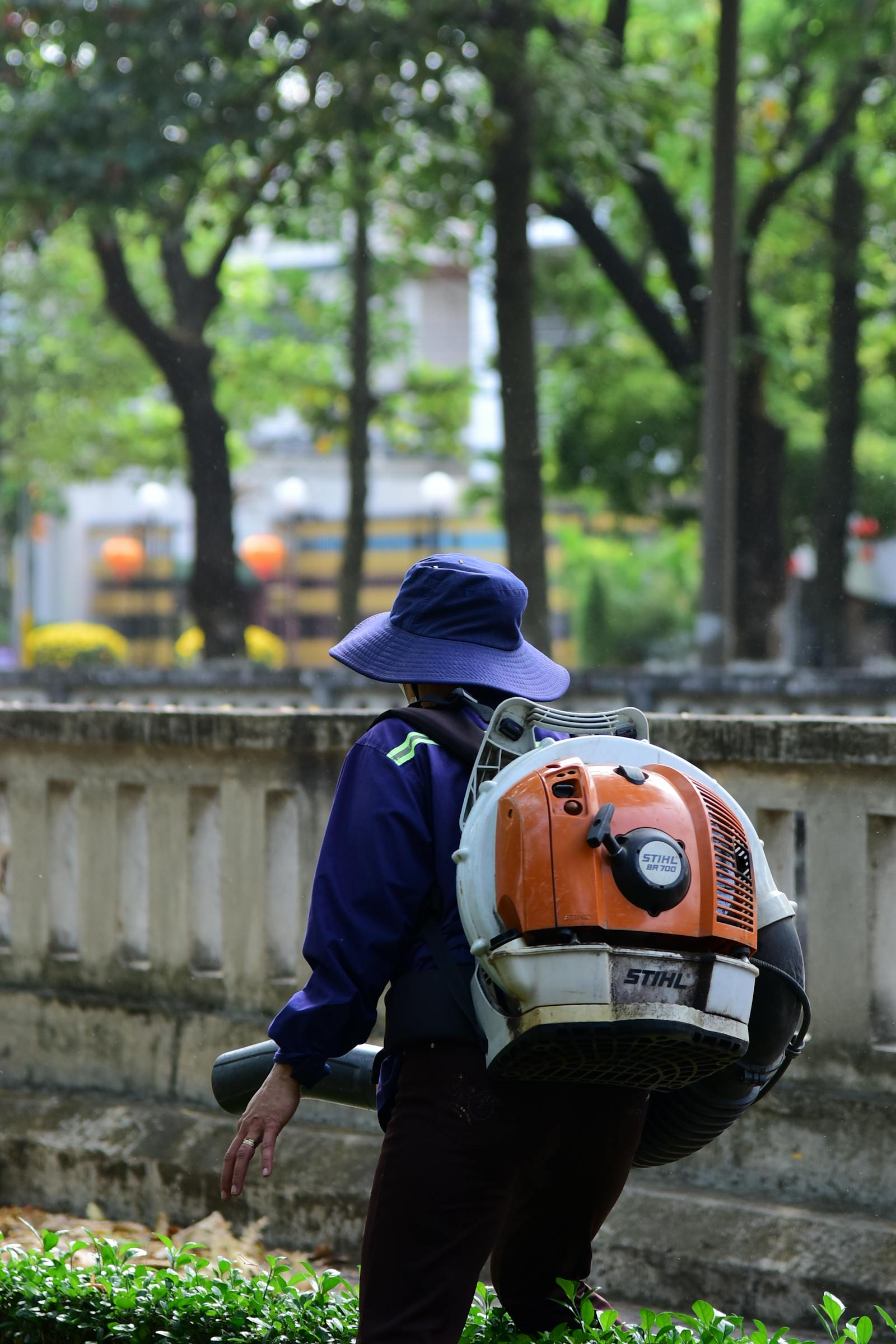 Backpack-blower clearing fall leaves into a tidy pile on a residential Katy lawn.